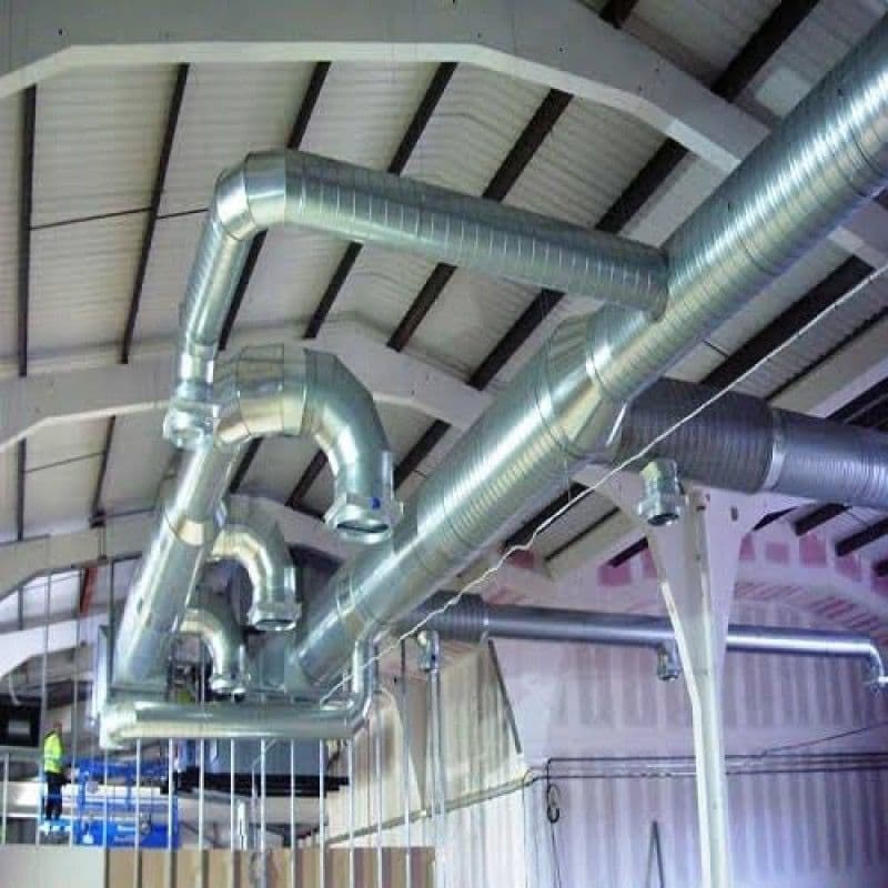 Metal ductwork in an industrial ceiling for air ventilation and circulation.